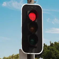 A traffic light with the red circle illuminated to signal “stop.”