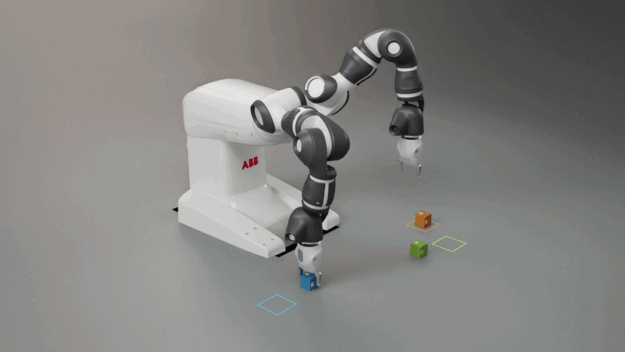 YuMi beside colored cubes and matching outlined targets at left; at right, a gripper holds a green cube above a shallow blue box on a table.